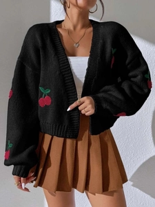 Close-up of cherry embroidery and thick knit texture on a black open cardigan sweater