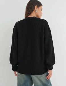 Detail view of the vertical knit pattern and ribbed cuff on a black cardigan's back