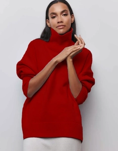 Détail d'un pull rouge à col montant avec poignets côtelés et une coupe décontractée