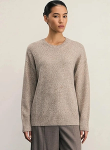 Detail of oat-beige crewneck knit sweater texture with soft wool-blend fabric