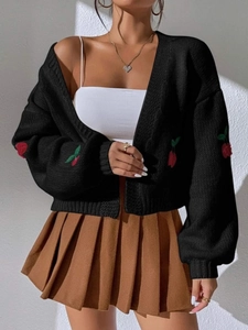 Close-up of cherry embroidery and thick knit texture on a black cardigan sweater