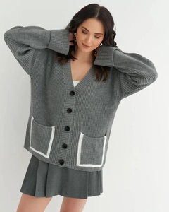Detailed close-up of dark grey V-neck cardigan with white contrast trim pockets