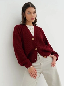 Close-up of oversized burgundy knit cardigan featuring large wooden buttons and V-neckline