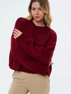 Detailaufnahme von bordeauxrotem Strickpullover mit Rundhalsausschnitt und Rippbündchen
