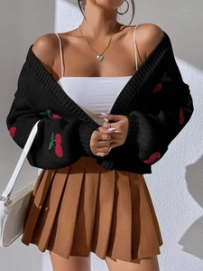 Detail of black cherry embroidery cardigan paired with a brown pleated mini skirt