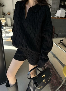 Detail of black cable knit sweater and shorts set with V-neck collar and wool texture