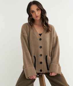 Close-up of oversized khaki knit cardigan with V-neckline and black contrast pocket detail