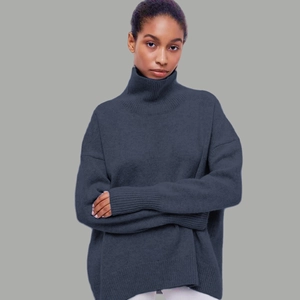 Détail d'un pull à col roulé oversize bleu-gris foncé avec poignets côtelés