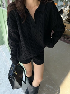 Detail of black cable-knit sweater set with V-neck collar and matching shorts