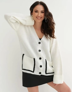 Close-up detail of white V-neck knit cardigan with black contrast pockets and large buttons