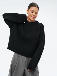 Detailansicht der feinen Strickstruktur und des Rundhalsausschnitts des schwarzen Pullovers