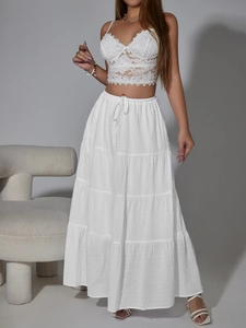 Dettaglio della gonna lunga bianca a balze con coulisse e tessuto jacquard a pois