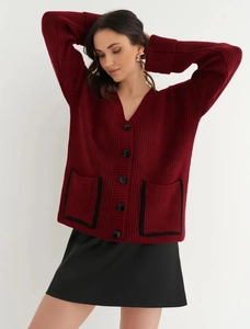 Detail of burgundy V-neck cardigan featuring chunky knit texture and black button accents