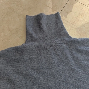 Gros plan détaillé du col roulé côtelé sur un pull en maille grise pour femme