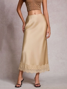 Détail de l'élégante jupe midi en satin champagne avec dentelle délicate au bas