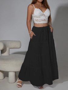 Dettaglio di gonna lunga a balze con coulisse e un top corto in pizzo all'uncinetto