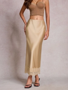 Détail d'une jupe longue en satin champagne avec bordure en dentelle et taille haute