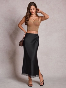 Détail d'une jupe midi en satin noir avec bordure en dentelle délicate et taille haute