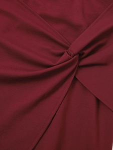 Détail macro d'une mini-jupe bordeaux avec un nœud torsadé et une texture de tissu plissé