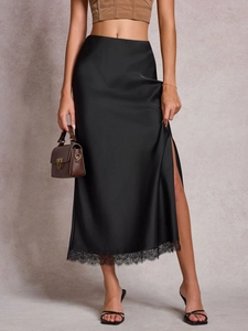 Jupe mi-longue en satin noir avec ourlet en dentelle délicate et fente latérale chic
