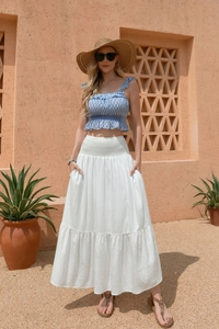 Detail of high waist pleated white maxi skirt with pockets and elastic waistband