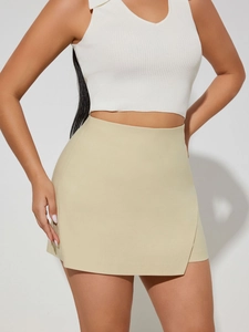 Detail of high-waist wrap skort in beige with asymmetrical hem and clean tailoring