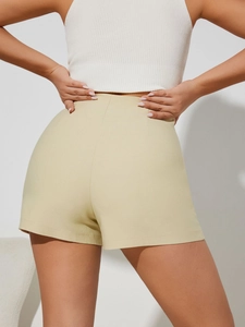 Rear view of high-waisted pale yellow skort featuring a slimming back waist tailoring design