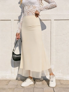Détail de la jupe sirène crème à taille haute avec ourlet en mesh transparent et coupe ajustée