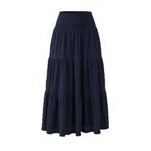 Detail of high-waist navy maxi skirt featuring smocked elastic waistband and tiered design