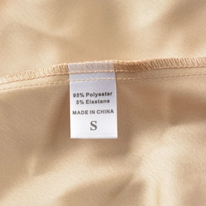 Gros plan de l'étiquette de la jupe en satin indiquant 95% polyester et 5% élasthanne