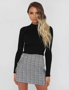 Detail of slim fit black ribbed knit crop top with a mock neck for a modern chic look