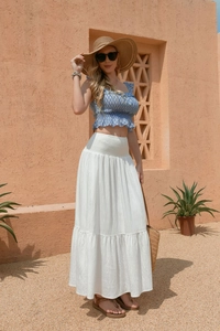 Close-up of high-waist tiered white maxi skirt with elastic smocked waist detail