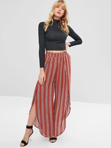 Detail of black ribbed turtleneck crop top paired with striped wide-leg pants