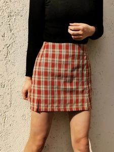 Détail d'une mini-jupe à carreaux rouge et jaune avec fentes latérales sur mannequin