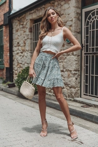 Detail of white crochet tank top with blue floral tiered ruffle skirt for women