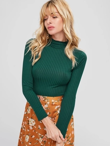 Close-up of dark green slim fit knit top with lettuce trim neck and ribbed texture