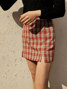 Détail d'une mini-jupe à carreaux rouge avec fente latérale et coupe moulante
