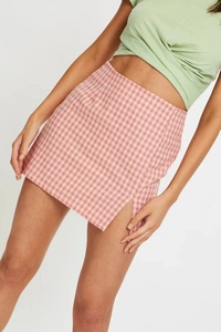 Détail de la fente latérale et du motif vichy rouge sur une mini-jupe à taille haute