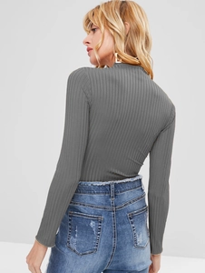 Detailed back view of a grey slim-fit ribbed long sleeve crop top with denim jeans