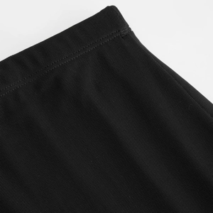 Détail de la taille de jupe en maille noire montrant la texture et les coutures