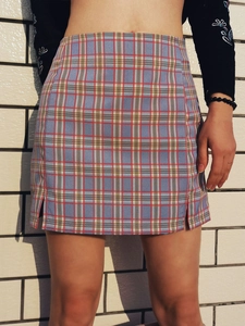 Détail de la mini-jupe à carreaux taille haute avec fentes latérales et motif tartan chic