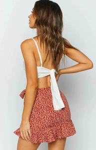 Detail view of the lace-up back design on a white crop top with ruffled floral skirt