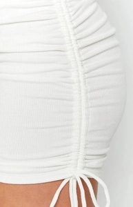 Detailed close-up of white ribbed knit fabric featuring adjustable side drawstring ruching