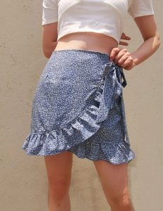 Detail of blue floral ruffle skirt with wrap waist and asymmetrical hemline texture