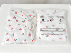 Detailed view of folded floral print white ribbed T-shirt in retail zip packaging with S-size label
