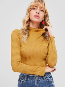Detail showing the mustard yellow ribbed knit texture and turtleneck design on the top