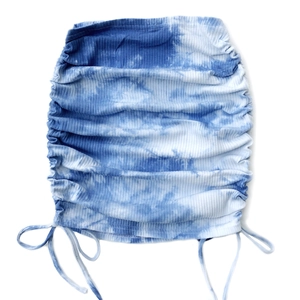 Detail of blue and white tie-dye knit skirt showing adjustable side drawstring and ribbed texture