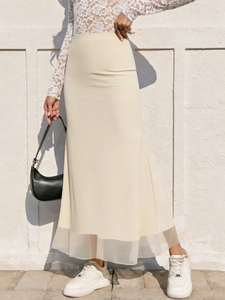 Jupe longue sirène beige à taille haute élégante avec ourlet en résille et coupe ajustée