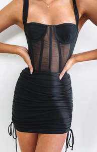 Detail of adjustable side drawstrings and ruched texture on black bodycon mini skirt
