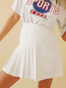 Vue détaillée de la mini-jupe plissée blanche avec taille haute et ourlet asymétrique